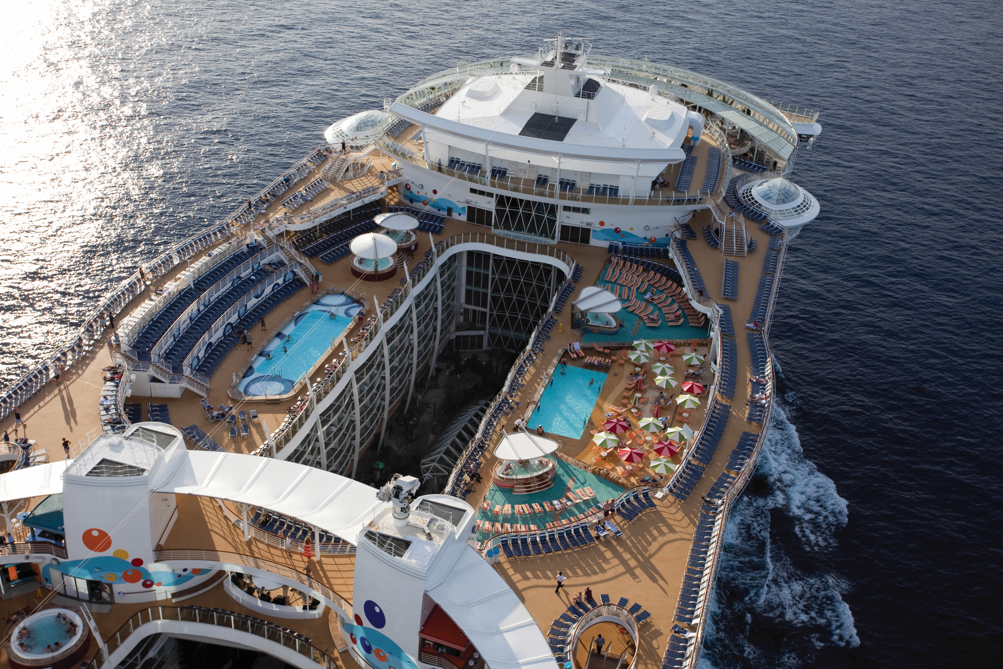 An aesthetic aerial photo of a cruise ship's deck as it travels across the ocean.