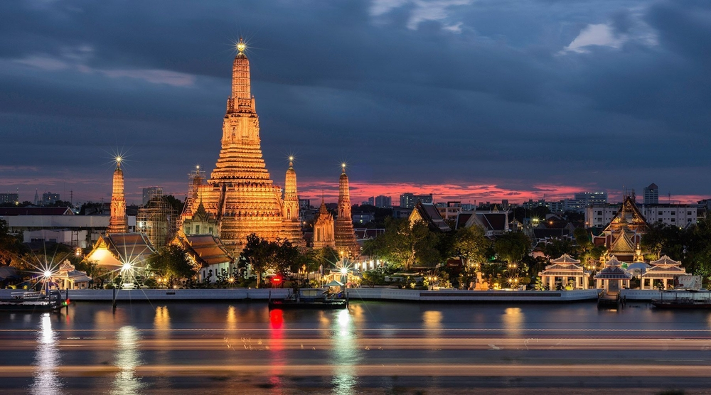 Photograph of Bangkok, Thailand, lit up at night against a dark sunset