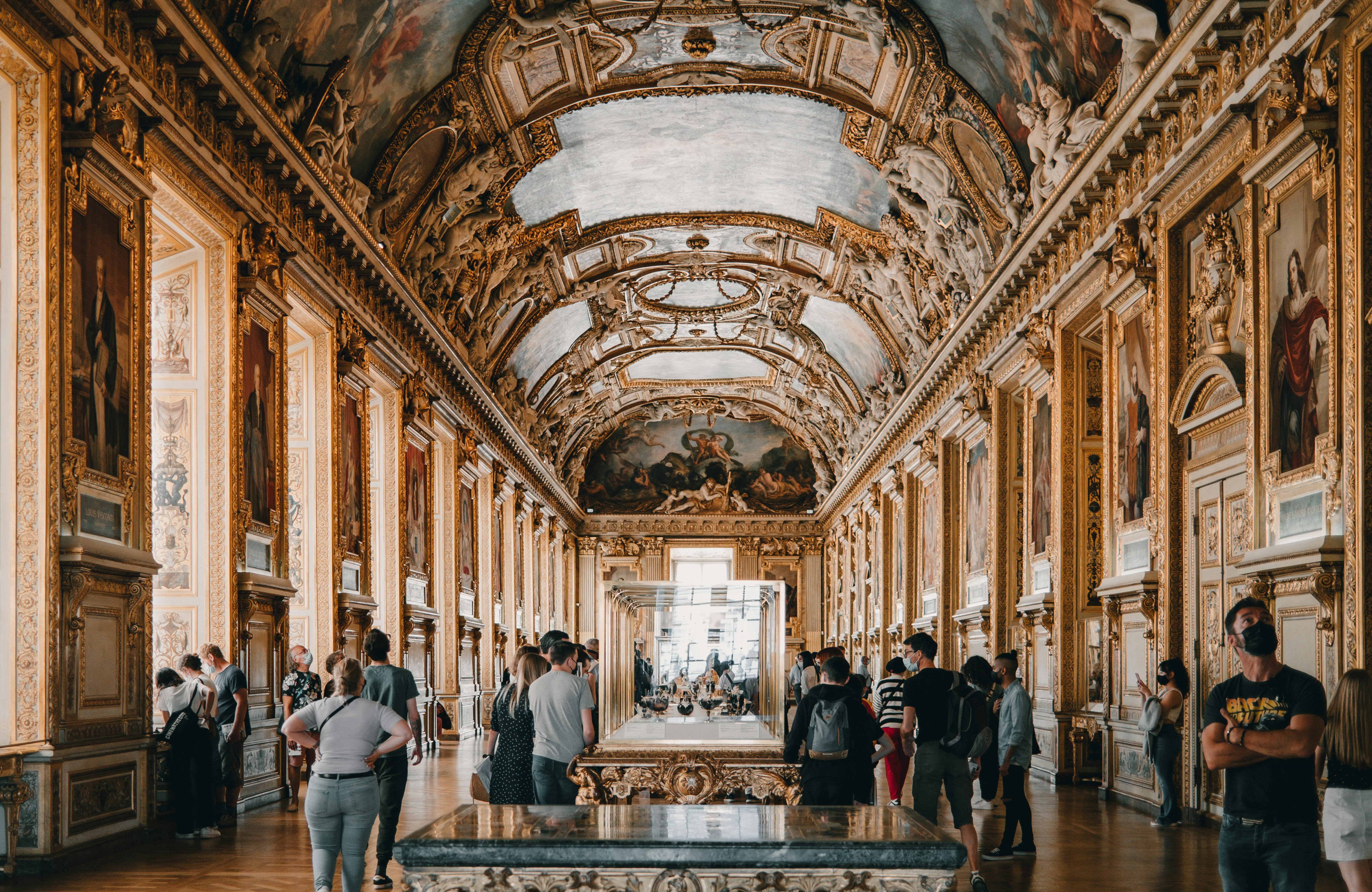 Inside the stunning galleries of the Louvre, old frech architecture reaches vaultd ceilings above museum guests and exhibit cases.