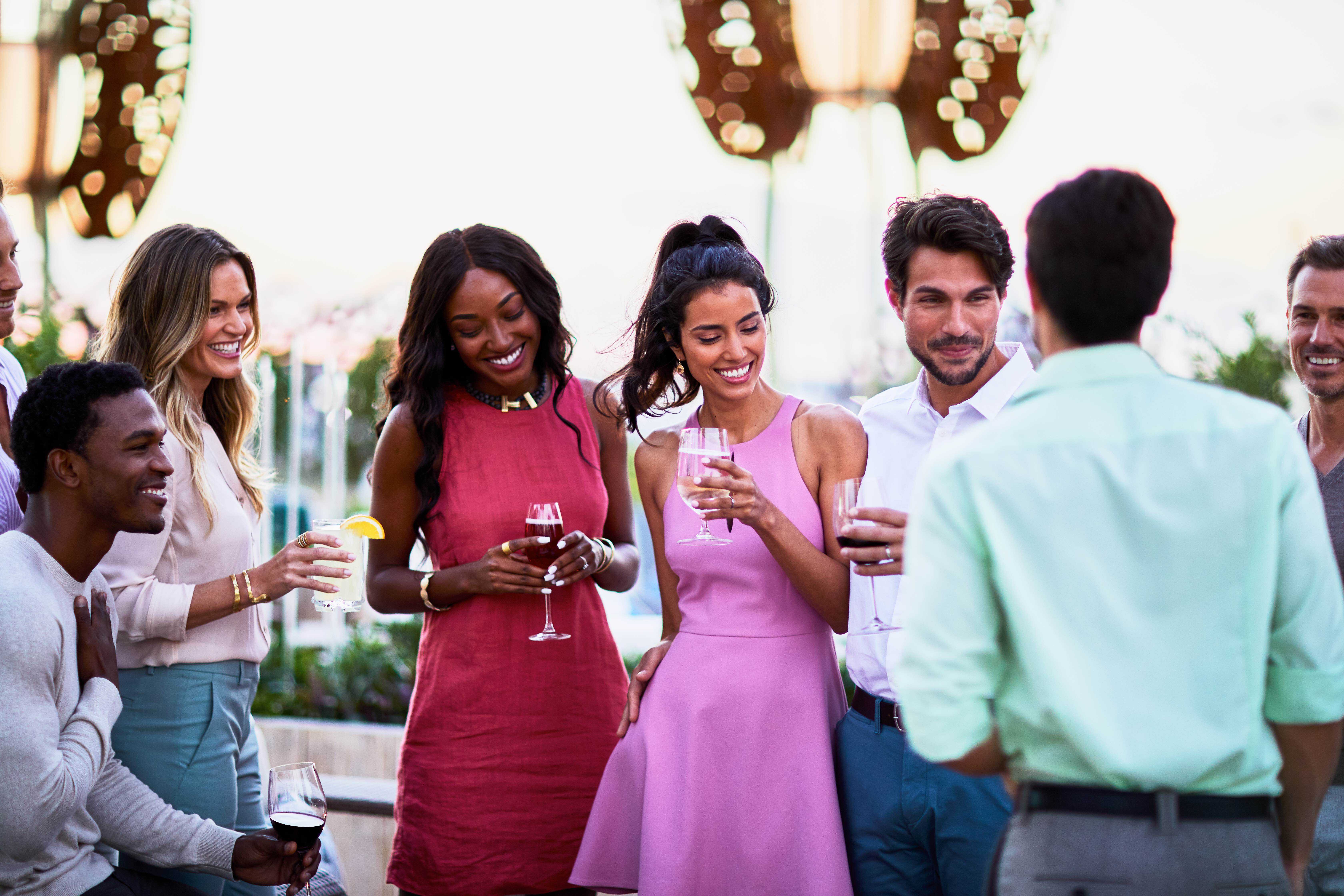 A mix of well-dressed people mingle with drinks.