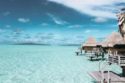 Photo of crystalline caribbean shallows, with over water bungalows. Taken by photographer Vincent Gerbouin