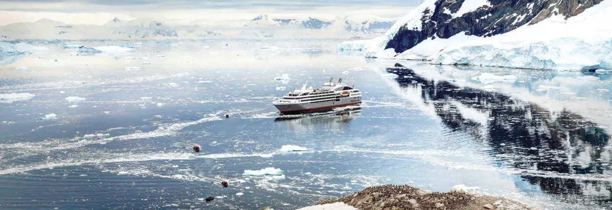 A cruise ship is seen in the distance of icy waters in Neko Harbor, Antarctica