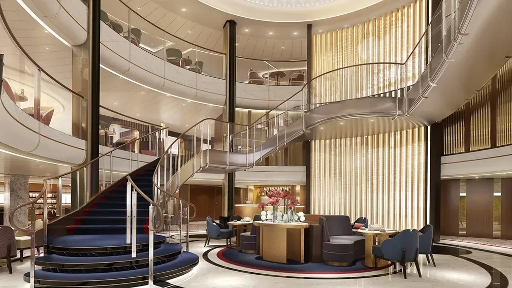 The grand lobby aboard Cunard's newest ship - The Queen Anne. Modern silvers and blues are used for this sweeping staircase and double balcony foyer.
